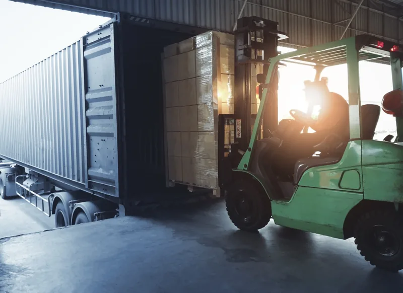 トラックの荷台に荷物を積み込むフォークリフト